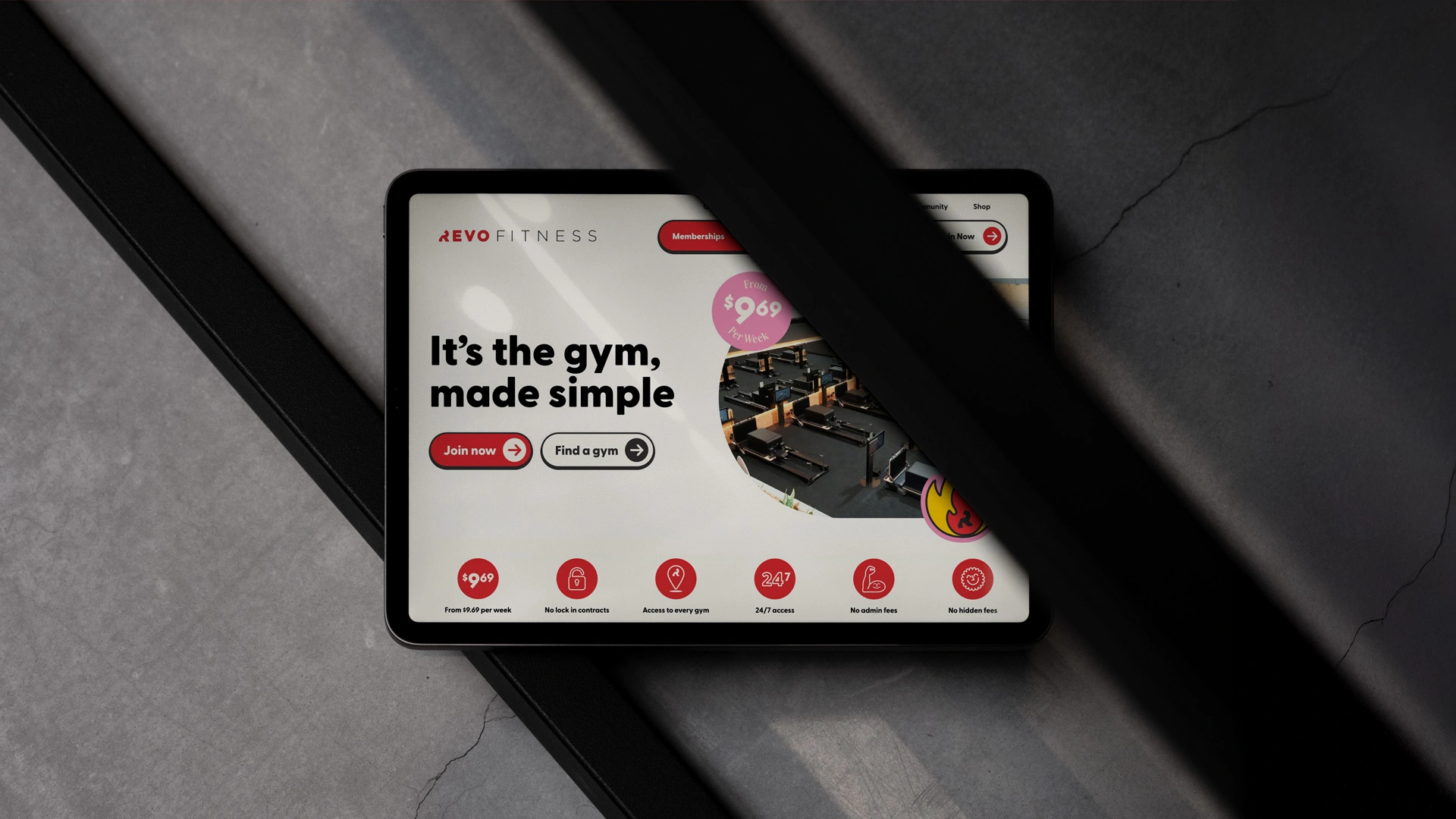 iPad mockup showing Revo Fitness app with 'It's the gym, made simple' tagline on a diagonal dark background