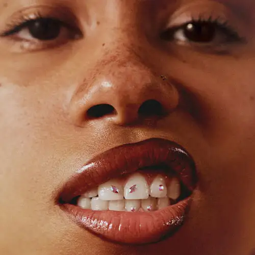 Close-up portrait of a person with full lips and intense direct gaze — bold fashion editorial portrait