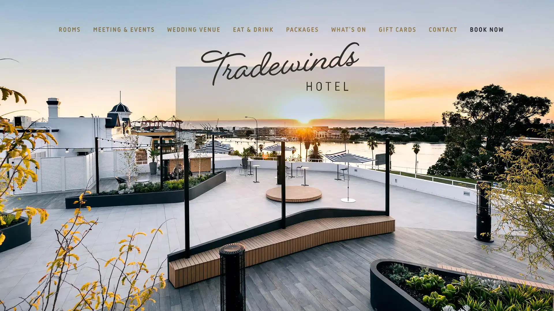 Tradewinds Hotel website displayed on a device mockup with the hotel's waterfront setting visible in the background