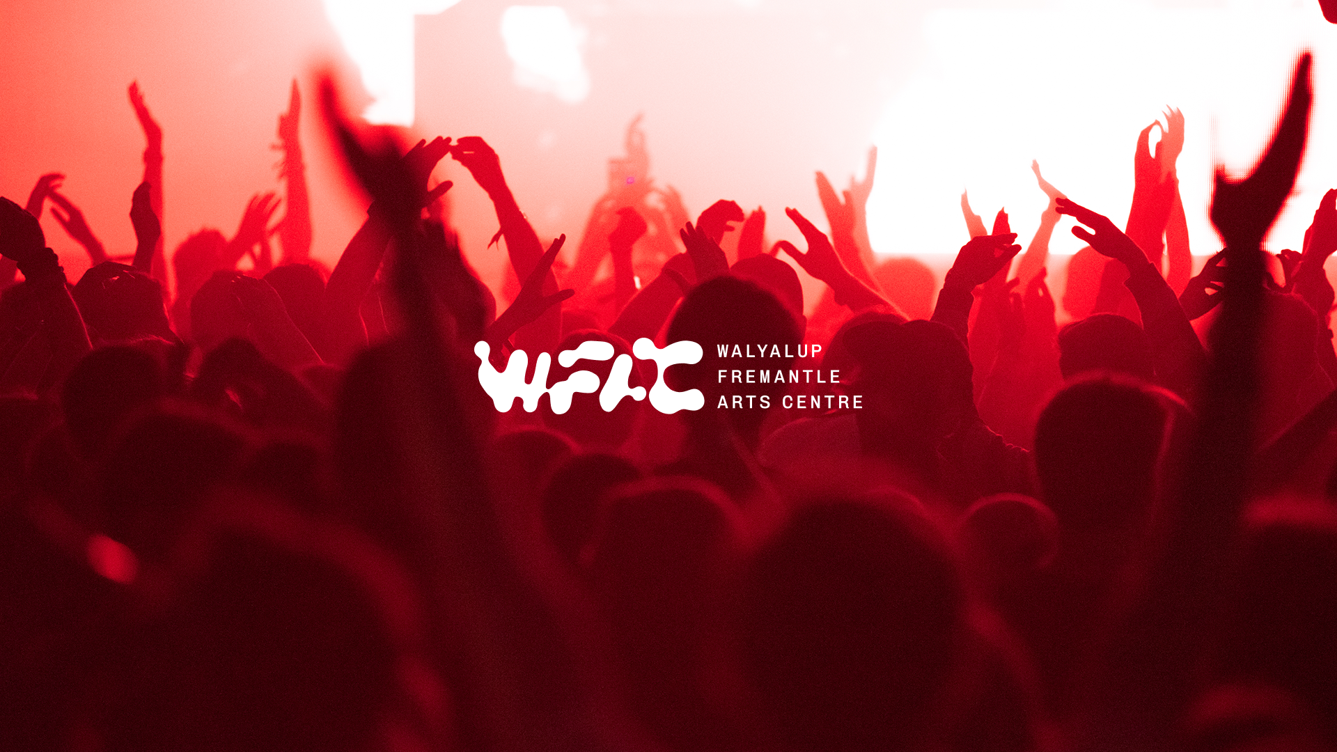 Concert crowd with raised hands and red stage lighting with WFAC branding overlay